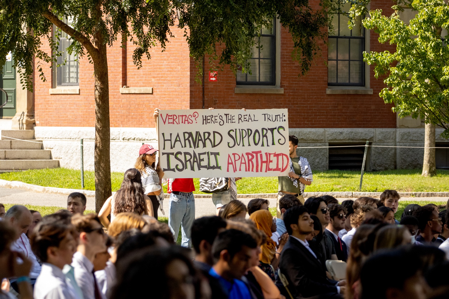 Members of the Harvard Undergraduate Palestine Solidarity Committee interrupted speeches and held signs in a demonstration at Convocation in September.